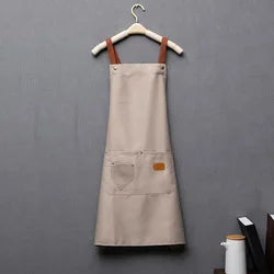 A beige waterproof kitchen apron hanging on a wooden hanger.