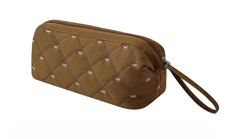 A brown quilted storage bag for a portable hair dryer and styling tool.