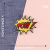 Yellow embroidered lettering patch with POW! text on a gray fabric background