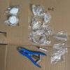 Set mit klebrigen Stressballen, klaren Plastiktüten und einem blauen Zange auf braunem Karton.