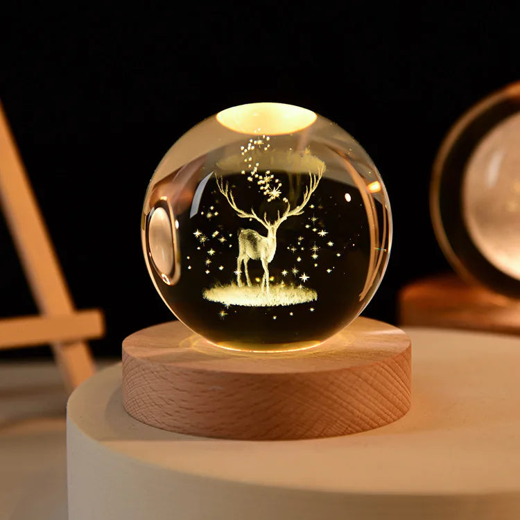 Laser engraved crystal ball night light with a silhouette of a deer on a wooden base