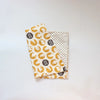 A rolled soft cotton baby pillowcase featuring a cartoon design with yellow and white elements.