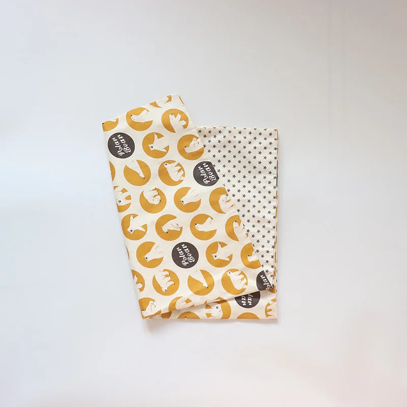 A rolled soft cotton baby pillowcase featuring a cartoon design with yellow and white elements.
