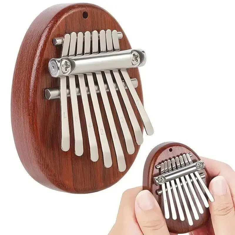 A wooden kalimba thumb piano with metal tines is shown being held by a hand.