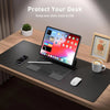 A laptop is placed on a black desk pad with a mouse and a coffee cup nearby, emphasizing desk protection.