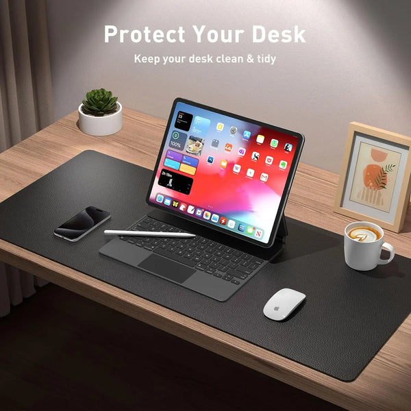 A laptop is placed on a black desk pad with a mouse and a coffee cup nearby, emphasizing desk protection.