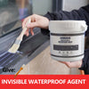 A hand holds a white plastic container of Invisible Waterproof Agent next to a wooden brush applying the product to a dark su