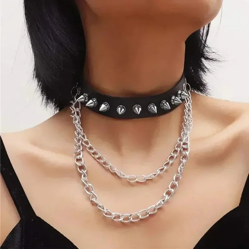Silver chain necklace with black spike studs around the neck