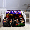 A black and white graphic print of the Kiss band on a flannel throw blanket displayed on a white sofa.