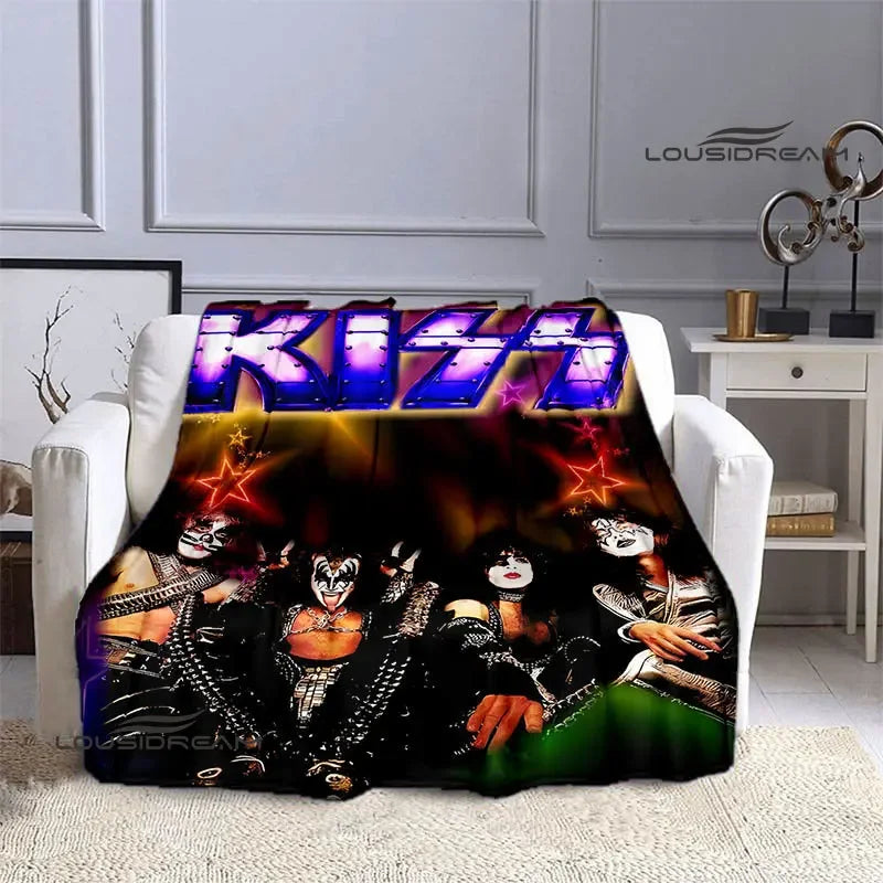 A black and white graphic print of the Kiss band on a flannel throw blanket displayed on a white sofa.