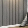Gray and white chevron striped wallpaper installed on a wall with a white baseboard.