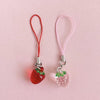 Red strawberry resin phone charm keychain with pink elastic cord and silver clasp
