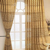 Cremefarbene und goldfarbene gemusterte Vorhänge hängen in einem weiß gerahmten Fenster.