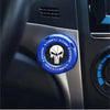 A close-up of a blue rotating protective cover for a car ignition start button featuring a skull design.