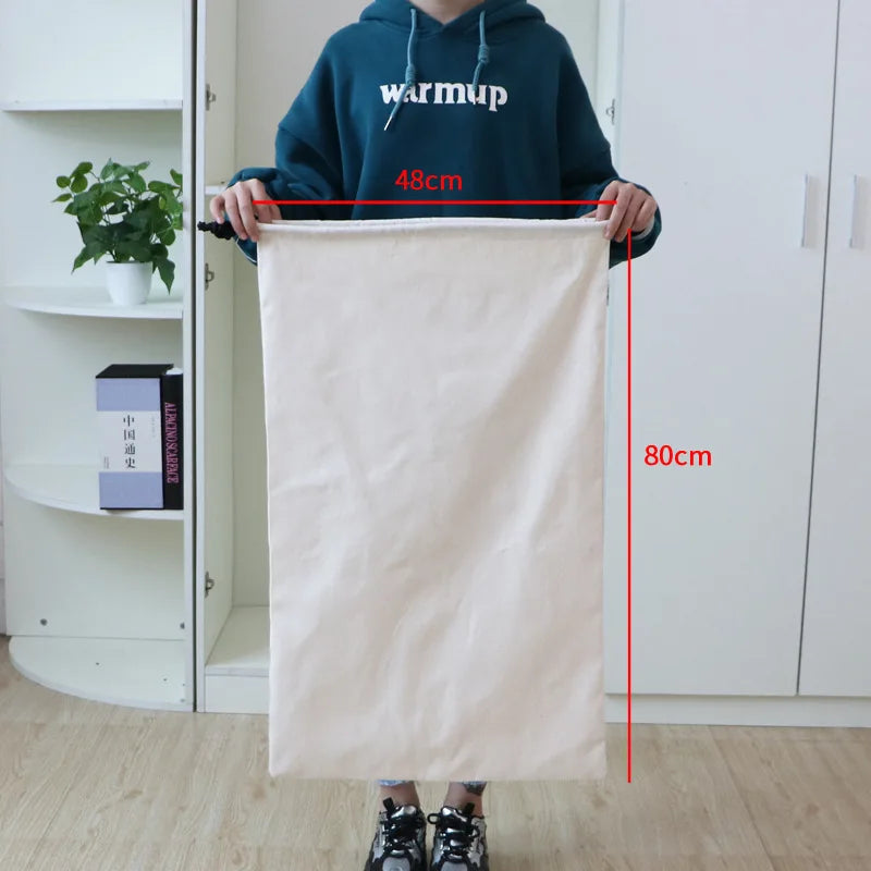A person holds up an extra large heavy-duty canvas laundry bag measuring 48cm by 80cm.