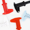 A collection of plastic vernier calipers and measuring tools in red, orange, and blue against a white background.