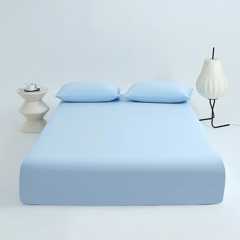 Light blue cooling ice-silk fitted sheet with two pillows and a modern lamp on a white background