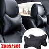A set of two black leather knitted car neck pillows shown in the interior of a car seat.