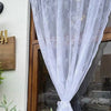 White floral lace sheer curtain panel hanging in a doorway