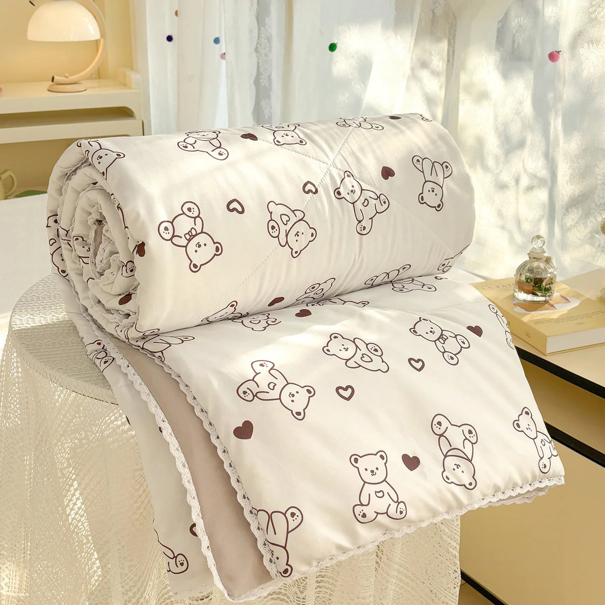 White panda print lightweight summer comforter rolled up with lace trim