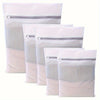 A stack of white reusable mesh laundry bags with zippered tops.