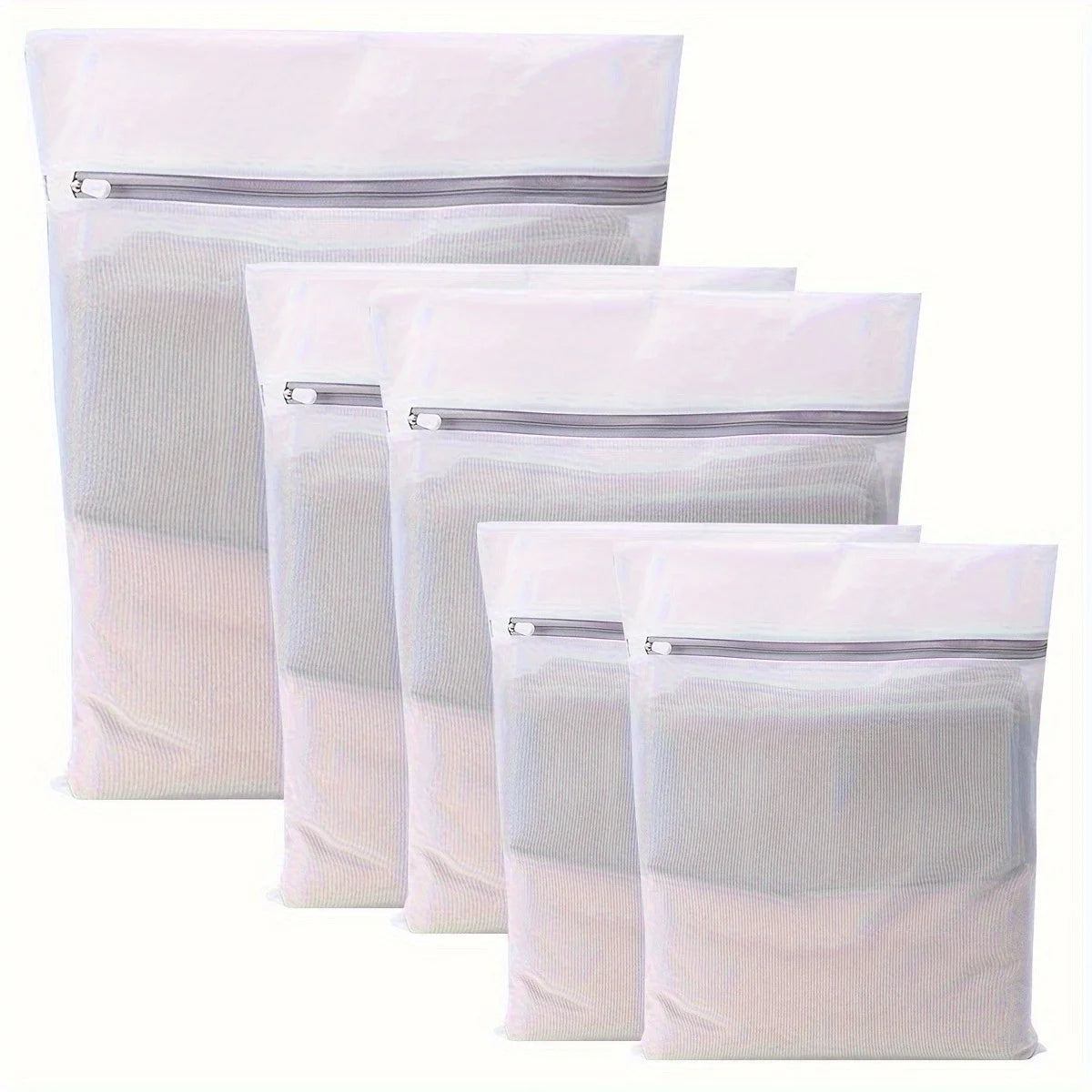 A stack of white reusable mesh laundry bags with zippered tops.