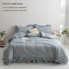 A gray plaid duvet cover set with two pillowcases and a white pillow core shown on a bed.