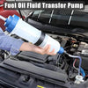 A hand is using a blue fuel oil fluid transfer pump to extract fluid from a vehicle engine.