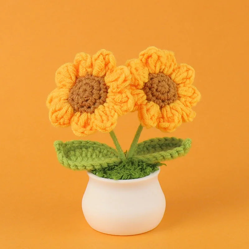 Handcrafted crochet sunflower in a green pot against an orange background