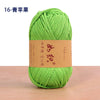 A ball of bright green cotton blend crochet yarn is shown on a wooden surface.