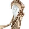 A beige satin sleep bonnet draped around a white mannequin head.