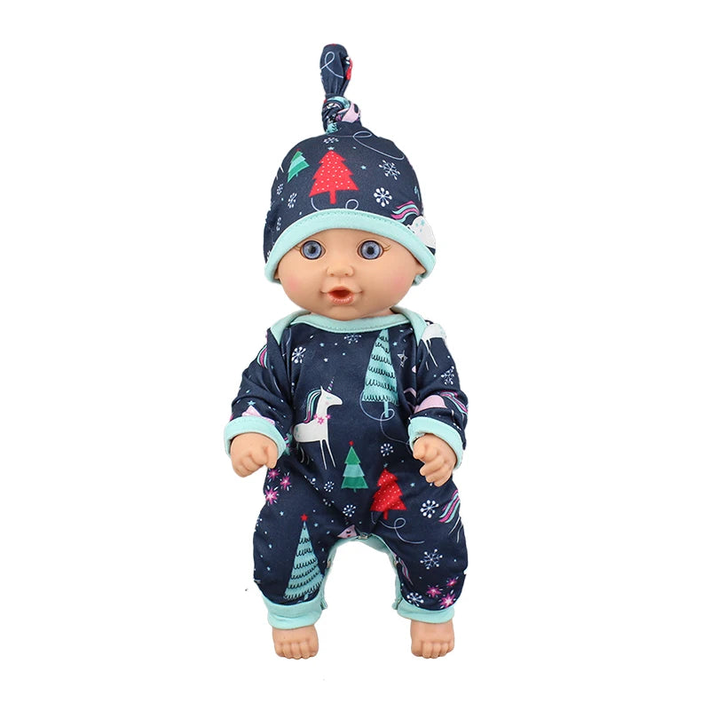 A baby doll wearing a dark blue jumpsuit outfit decorated with Christmas trees and snowflakes.