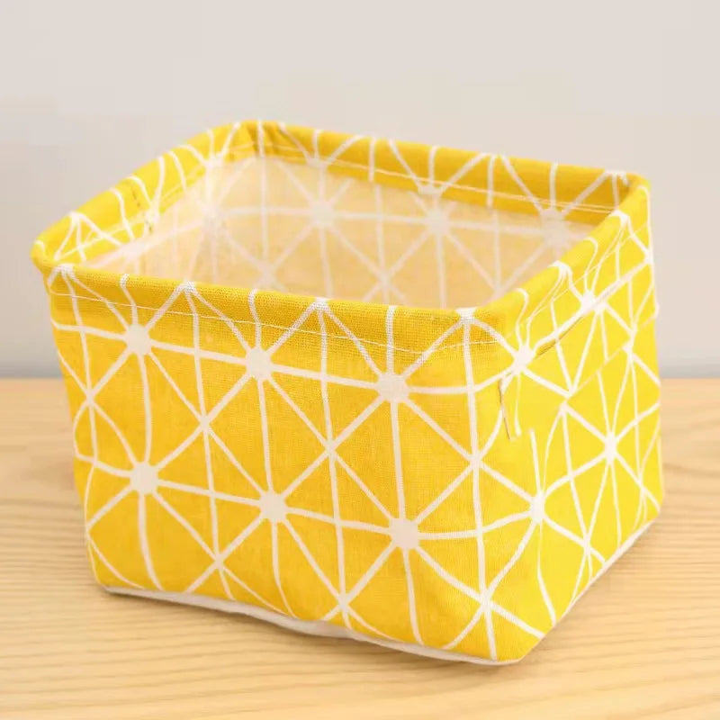 A bright yellow cotton and linen storage basket with a geometric pattern sits on a wooden surface.