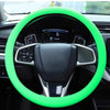 A steering wheel covered with a bright neon green silicone grip and a black leather rim in a car interior.