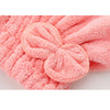 A pink microfiber hair drying towel with a bow-knot head wrap texture.