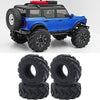 Blue RC truck with rubber mud terrain tires and a red accessory on a white background.