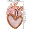 A heart-shaped patch made of pink and clear beads and rhinestones for clothing or crafts.