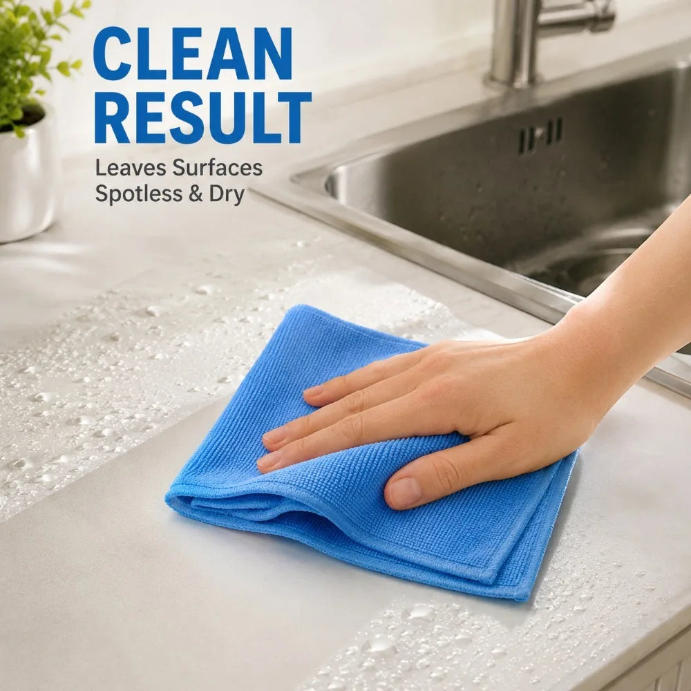 A hand wipes a stainless steel sink surface with a blue microfiber cleaning cloth, demonstrating a clean result.