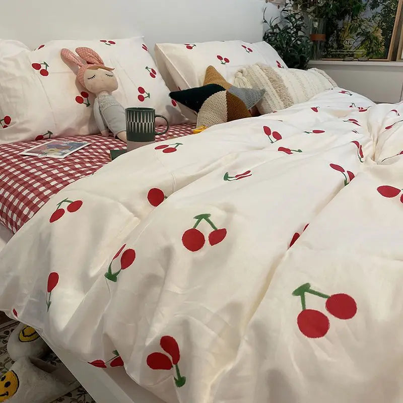 White bedding set featuring a duvet cover and pillows with a red cherry floral pattern.