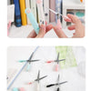 A collection of stainless steel cat paw portable scissors in various colors and sizes being held by a hand.