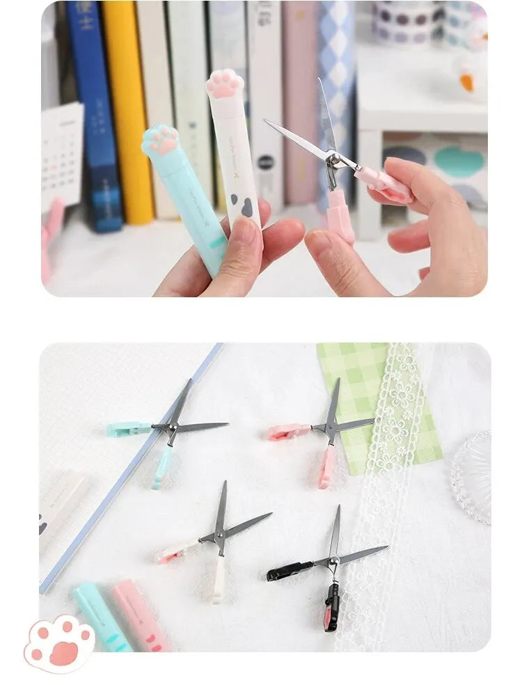 A collection of stainless steel cat paw portable scissors in various colors and sizes being held by a hand.
