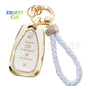 A gold-colored key fob cover with a white plastic body and a white braided strap.