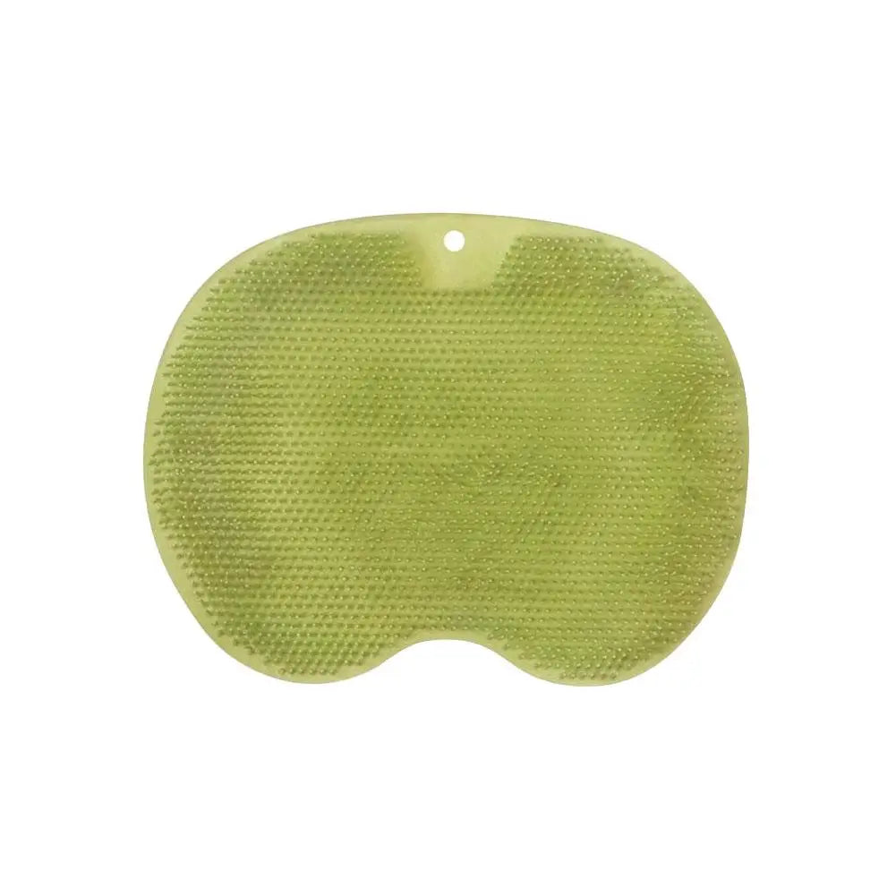 A light green ergonomic silicone foot scrubber with a suction base.