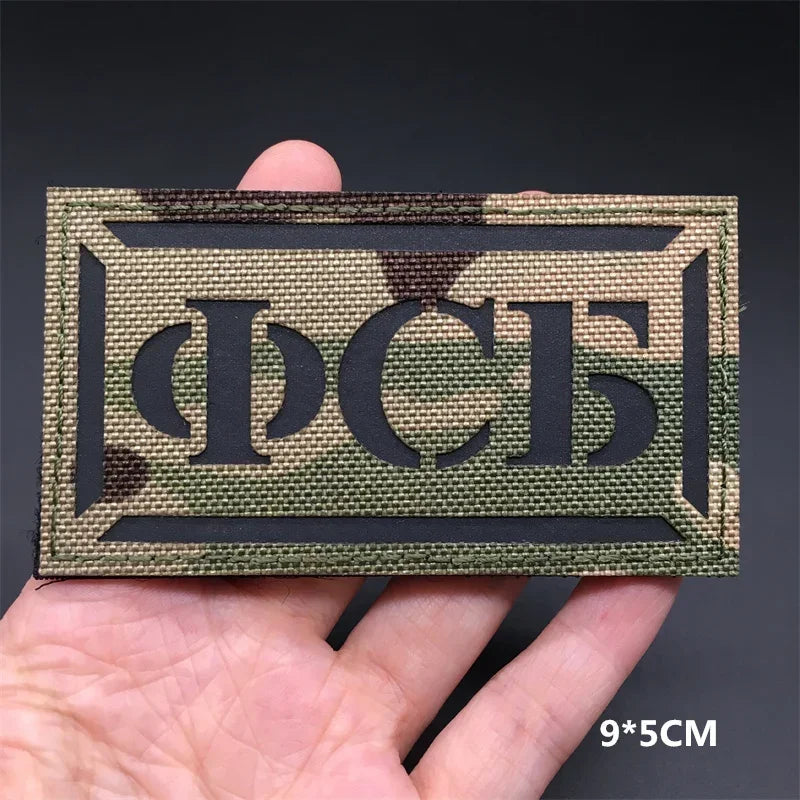 A rectangular tactical patch featuring the Cyrillic letters ПСС in a dark olive green camouflage pattern.