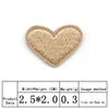 A beige heart shaped iron-on patch with visible stitching.