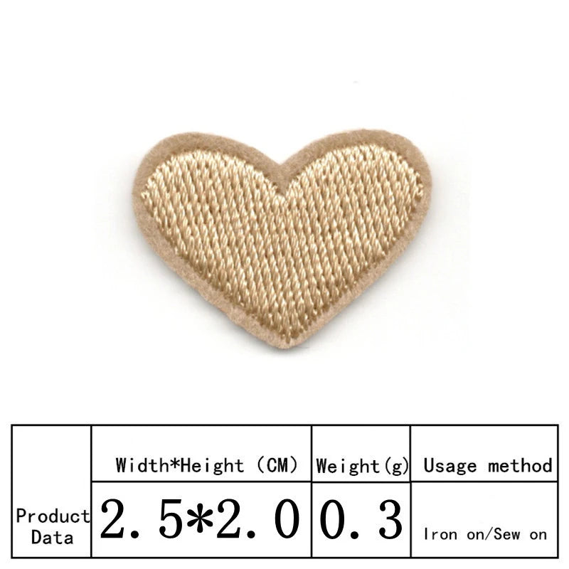 A beige heart shaped iron-on patch with visible stitching.