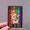 An embroidered patch featuring a fox face and the text CORGAY LOVE IS LOVE on a dark background.