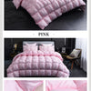 Pink quilted duvet cover and bedding set displayed on a bed in a modern bedroom setting.