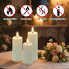 A set of white LED pillar candles displayed on a table with decorative flowers and safety warnings.