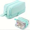 A mint green large capacity fabric pencil case with zipper details and an open view of its contents.